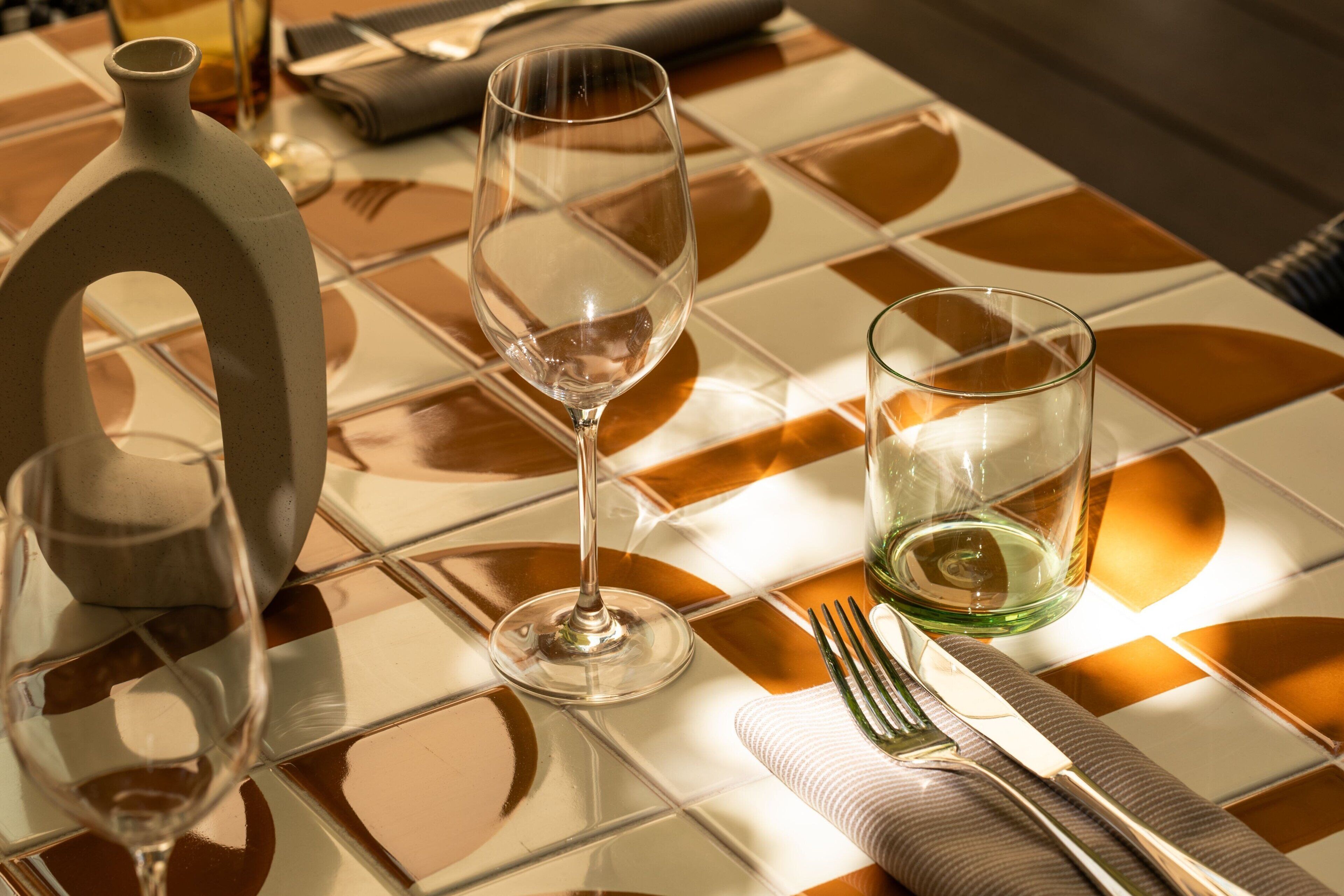 A table set with a wine glass, a water glass, a fork, and a knife.