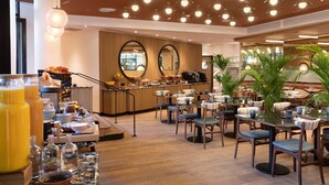 Un restaurant proposant un buffet, avec des tables rondes, des chaises et un espace bar.