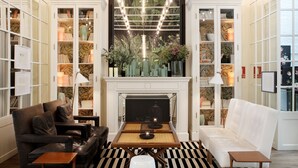 A living room with a fireplace, leather sofas, and a bookshelf filled with books and decorative items. - Ofelias Hotel (Barcelona)