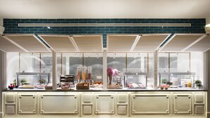 A buffet area with a variety of food items and a brick wall backdrop. - Ofelias Hotel (Barcelona)