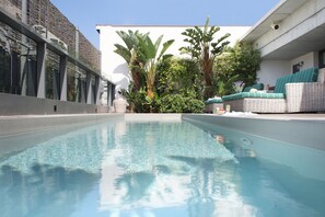 Una piscina al aire libre, tumbonas