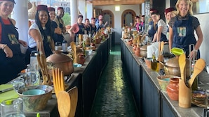 Una cocina con una barra larga, distintos utensilios de cocina y un conducto de agua central.
