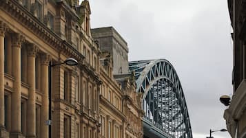 A historic building with classical architecture, a prominent bridge, and a street lamp.