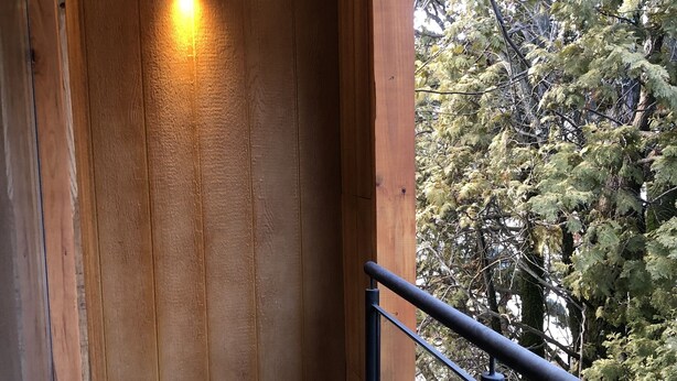 A wooden interior with a tiled floor and a railing overlooking a forested area. - Hosteria Hueney Ruca (San Martín de los Andes)