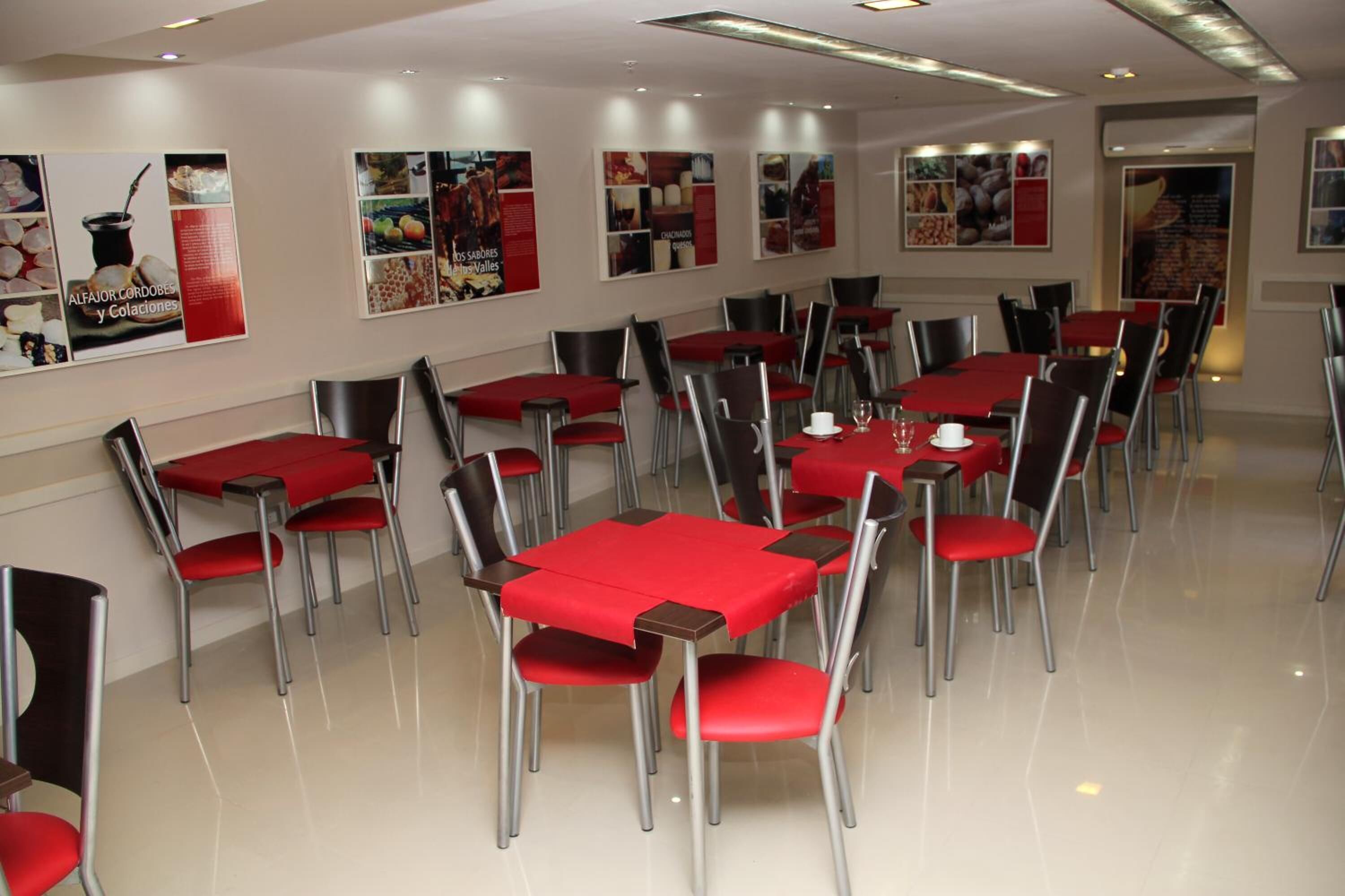 A dining area with tables and chairs, posters on the wall, and a clean, modern design.