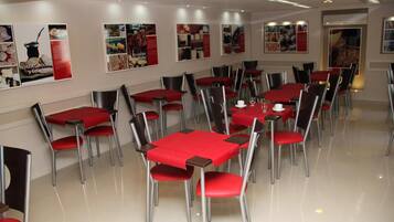 A dining area with tables and chairs, posters on the wall, and a clean, modern design.