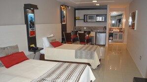 Une chambre d’hôtel avec deux lits, une petite kitchenette et une salle de bain.