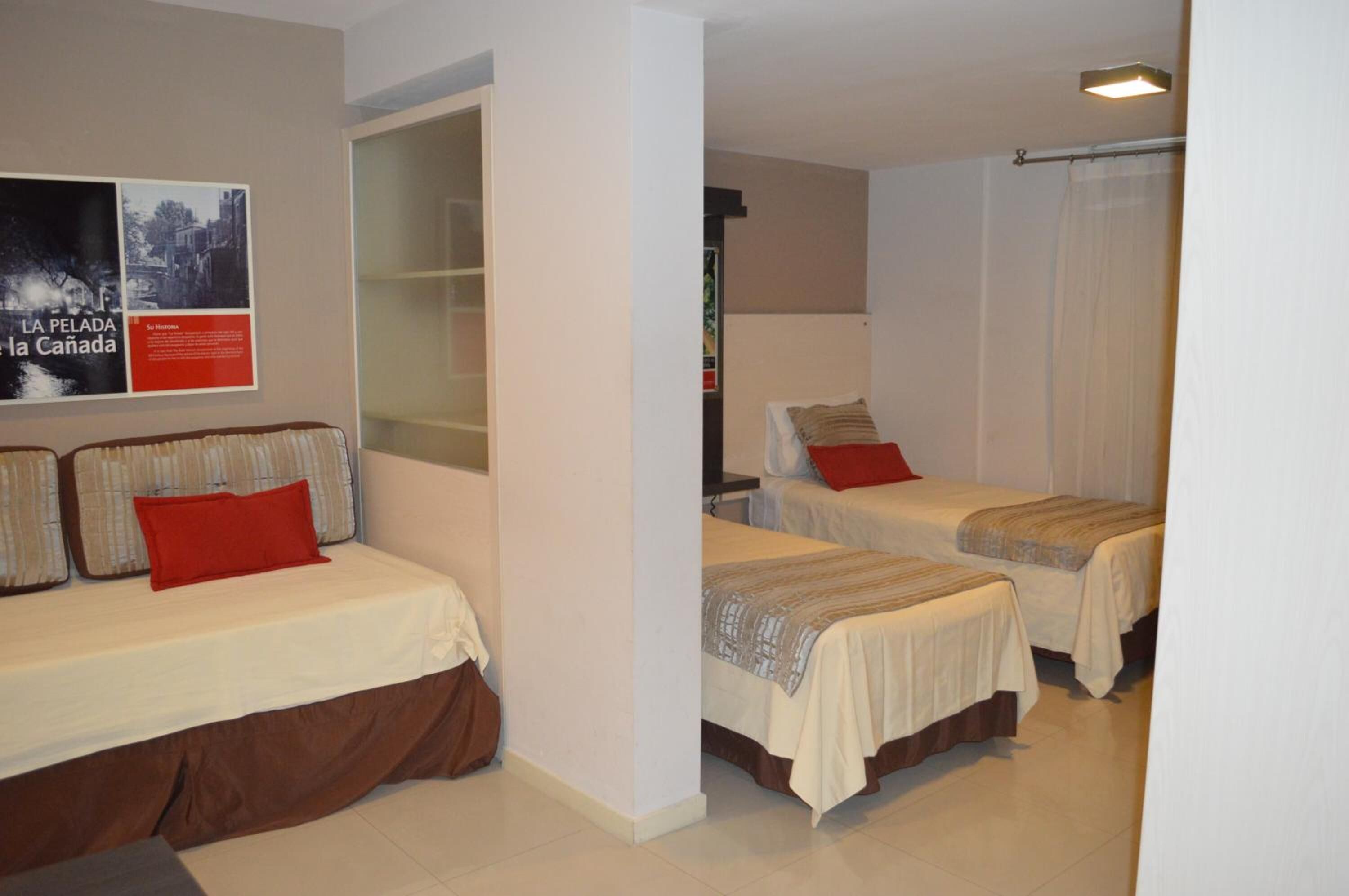 Habitación de hotel con dos camas, un armario y un cartel en la pared.