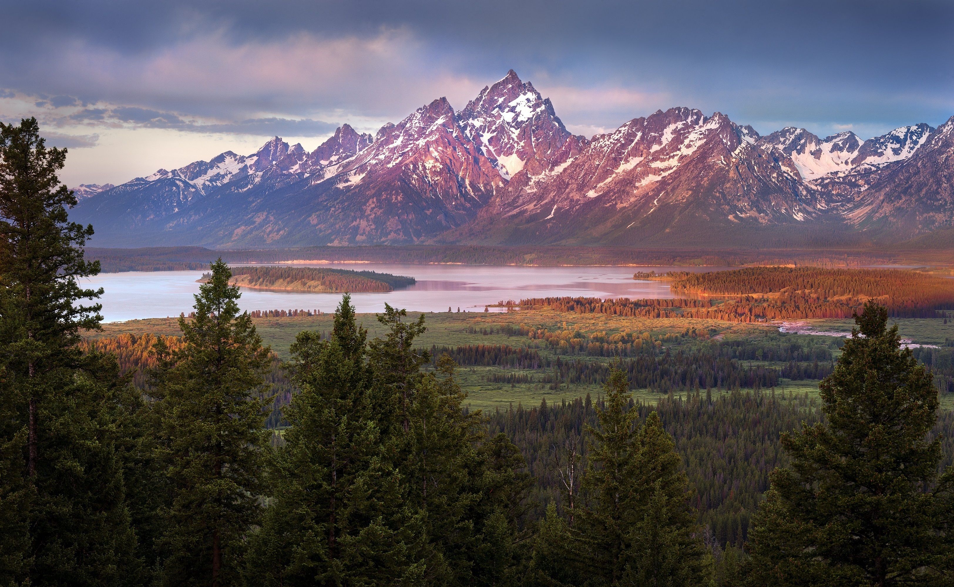 A mountainous landscape with a lake and forested area.