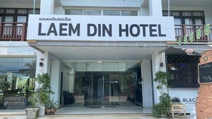 The front entrance of Laem Din Hotel with a signboard, glass doors, and potted plants. - Laem Din Hotel Chaweng (Koh Samui)