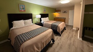 A hotel room with two beds, a small kitchenette, and a door leading to another room. - Executive Inn and Kitchenette Suites (Eagle Pass)