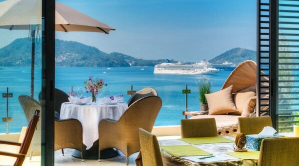 Relax in style with a comfortable seating area overlooking the sea and a distant cruise ship.