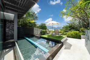 Relax by the pool surrounded by lush greenery and a serene atmosphere.