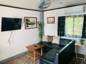 Luxury Condo, 1 King Bed, Ocean View, Poolside | Living area | 32-inch LCD TV with cable channels, TV, books - BADLADZ Beach and Dive Resort (Puerto Galera)