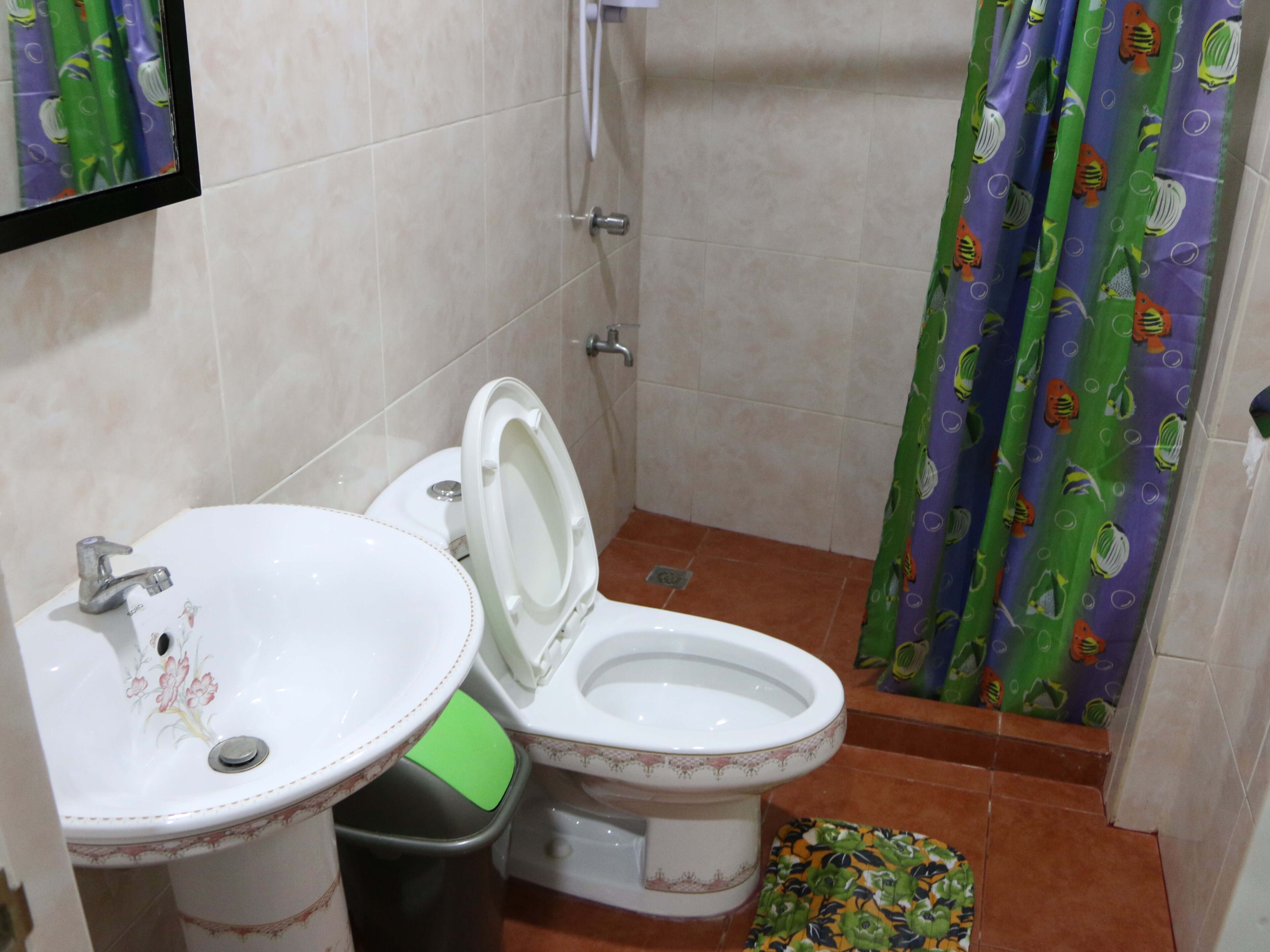 A bathroom with a toilet, sink, and shower.
