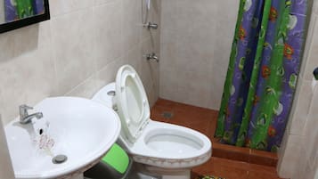 A bathroom with a toilet, sink, and shower.