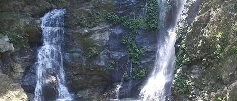 A waterfall cascading over rocky terrain with a pool at the base.