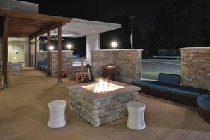 A stone fire pit with seating, a covered patio area, and a view of the street. - SpringHill Suites Philadelphia Valley Forge/King of Prussia (King of Prussia)