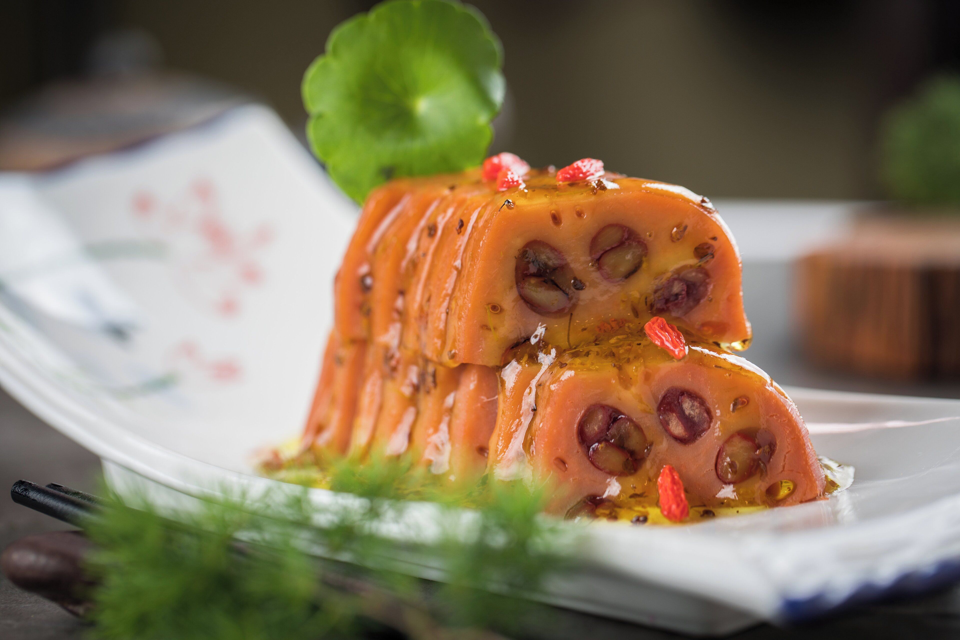 A dish with a layered structure, garnished with herbs and small red berries.