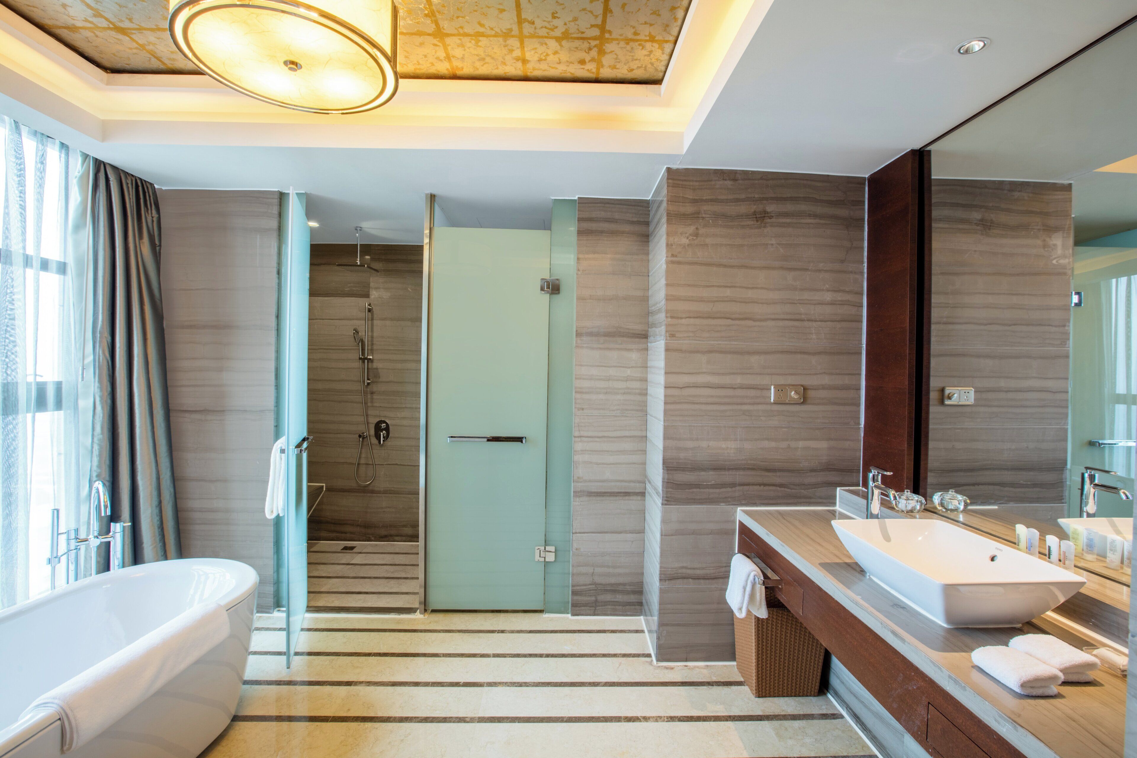 Een moderne badkamer met een bad, een douche, een wastafelmeubel en een grote spiegel.