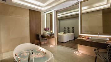 Relax in a spacious bathroom with a bathtub, large mirror, and vanity area.