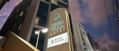 The exterior of the Brisa Praia Hotel with its modern architecture and illuminated signage.