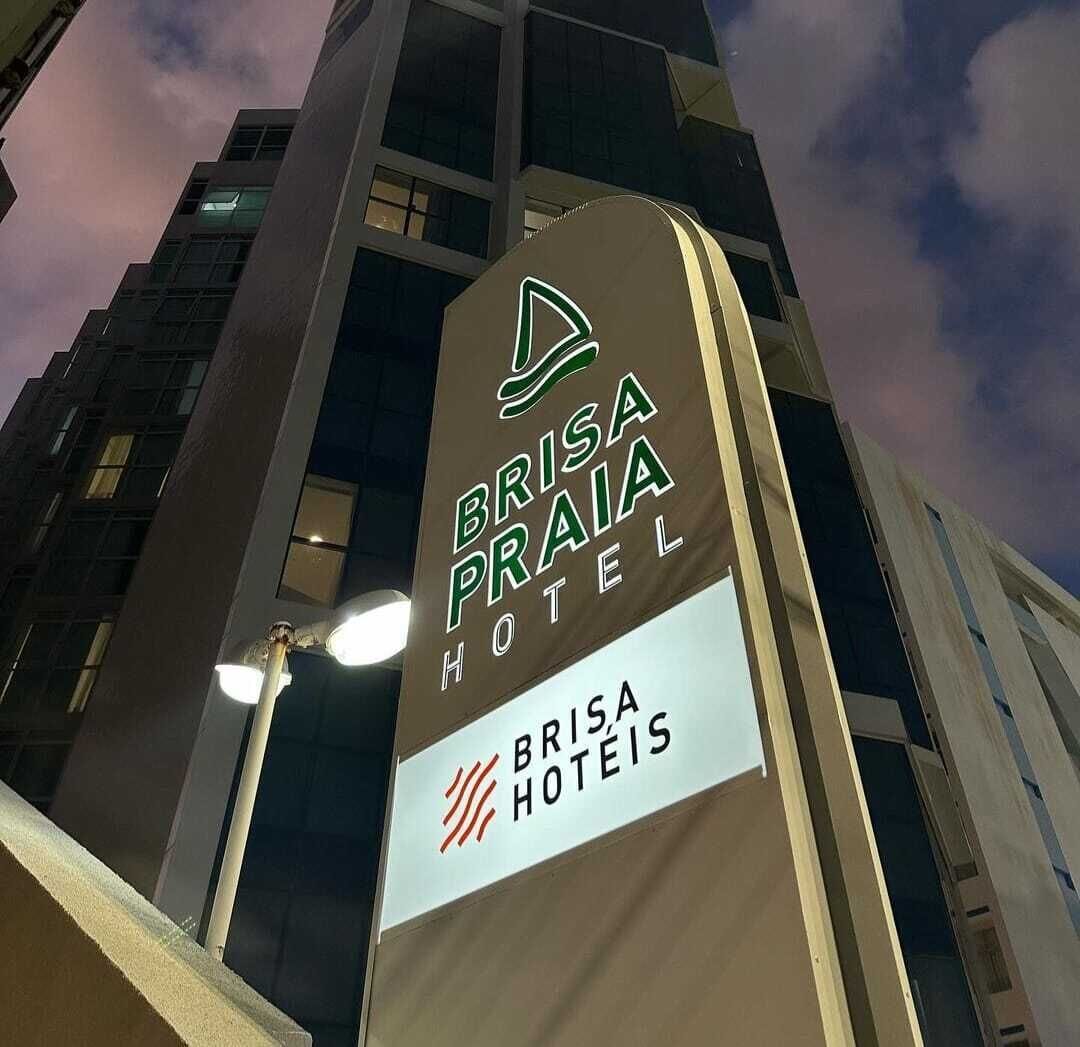A sign for Brisa Praia Hotel with a modern design and a logo.