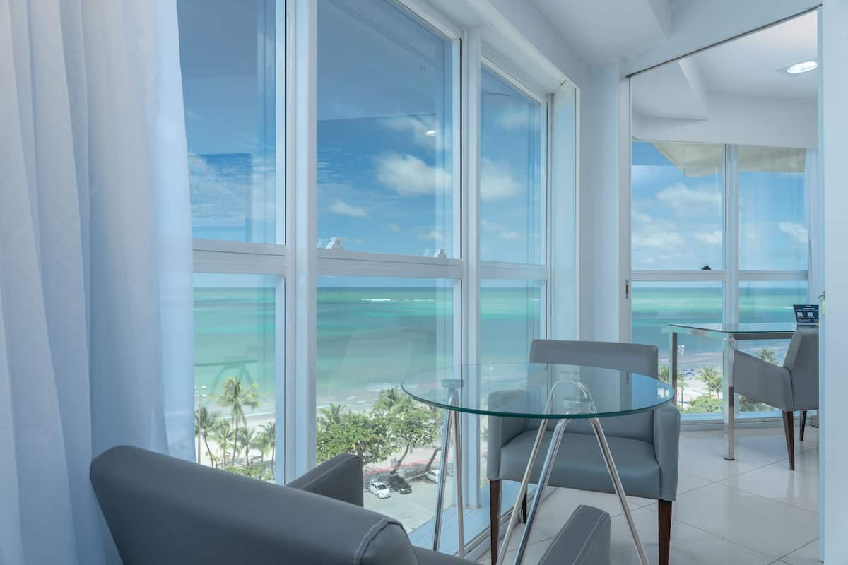 A modern room with large windows, a glass table, and two chairs.