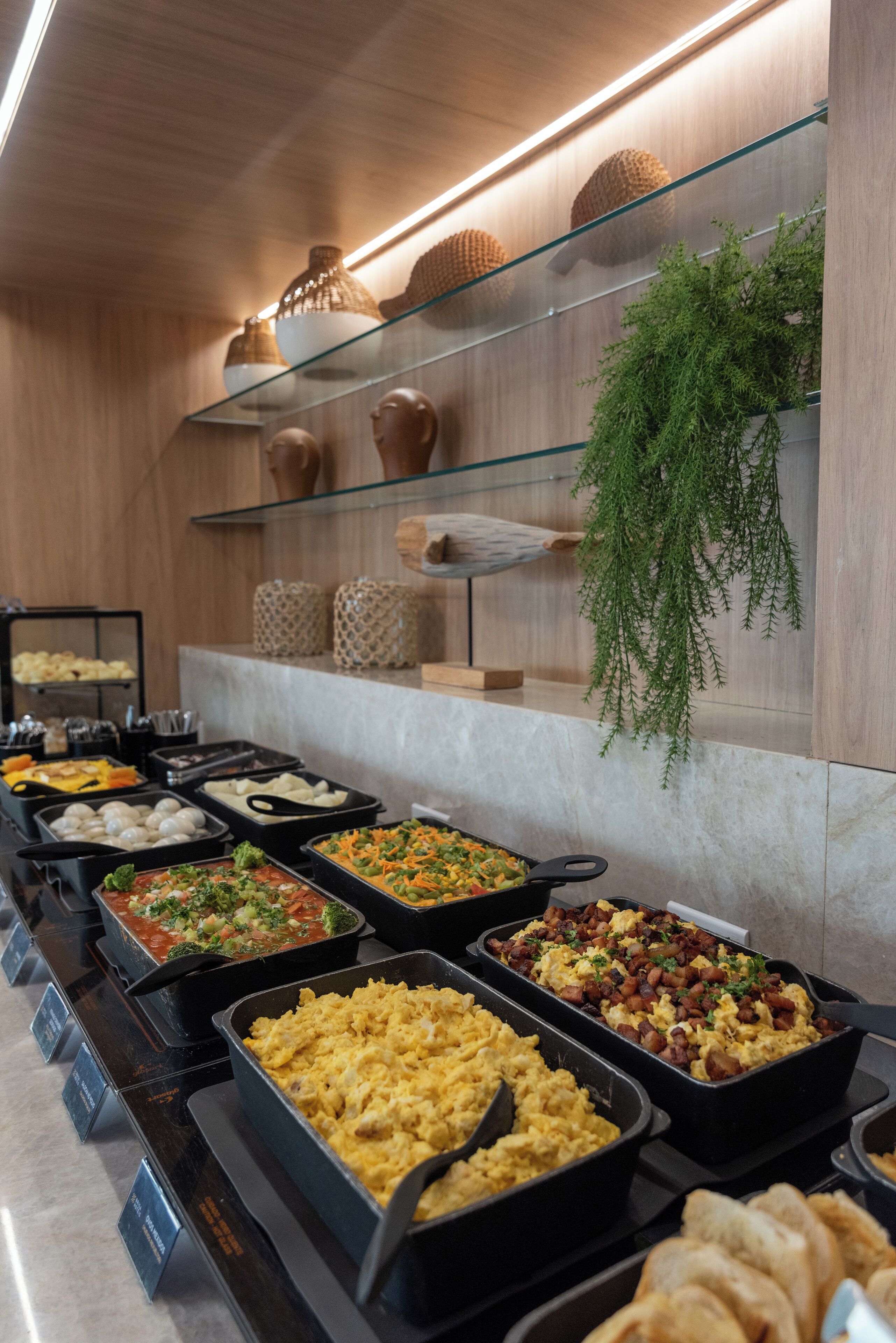 A buffet with various food options, including salads, eggs, and bread.