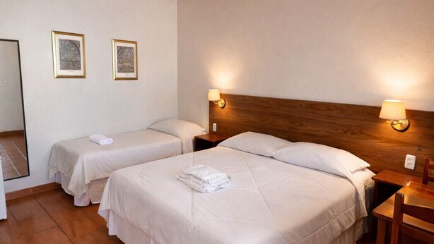 A hotel room with two beds, wooden headboards, and a wooden ceiling. - Pousada Porto Praia (Arraial do Cabo)