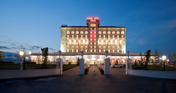 A large hotel with a prominent sign reading "Grand Hotel Italia" at the top.