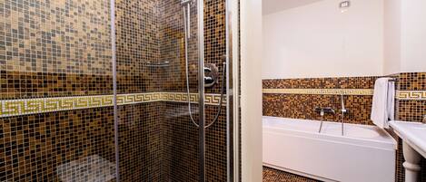 Ein Badezimmer mit Dusche, Badewanne und Fliesenboden.