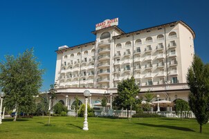 Un hotel grande y de varios pisos con un cartel llamativo que dice "Grand Hotel Italia".