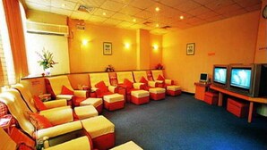 A room with multiple massage chairs, a television, and a small table. - Wings Hotel Guangzhou (Foshan)