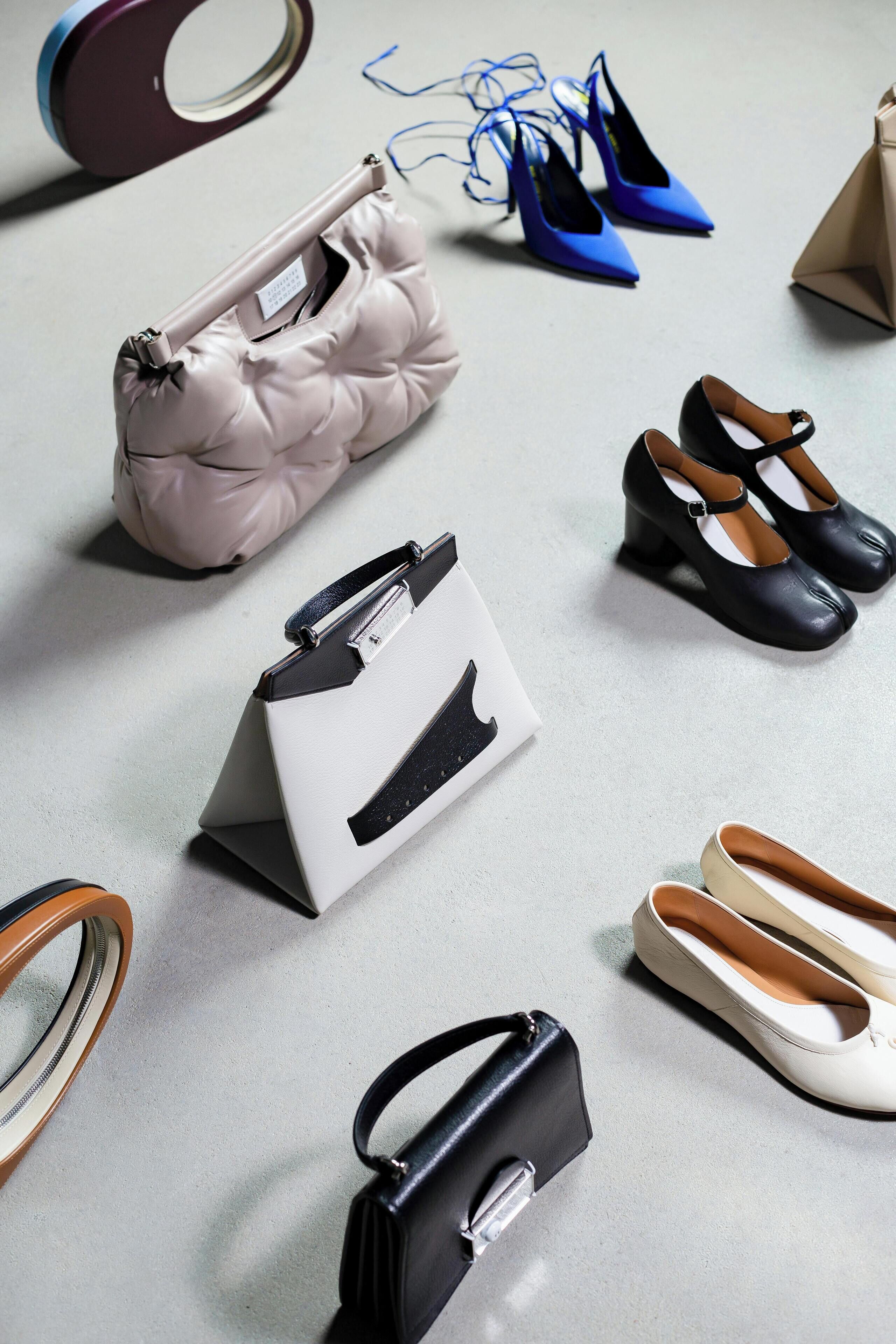 A variety of shoes and handbags on a flat surface.