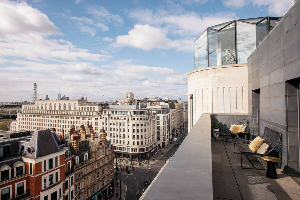 A modern building with a glass facade and outdoor seating area.