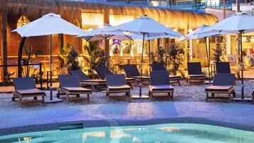 Piscine extérieure, parasols de plage, chaises longues