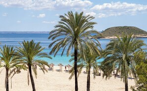 En la playa, arena blanca, sillas reclinables de playa, toallas de playa