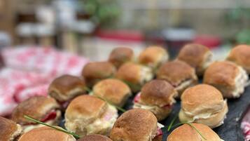 Una pizarra con mini sándwiches, algunos con rellenos a la vista.