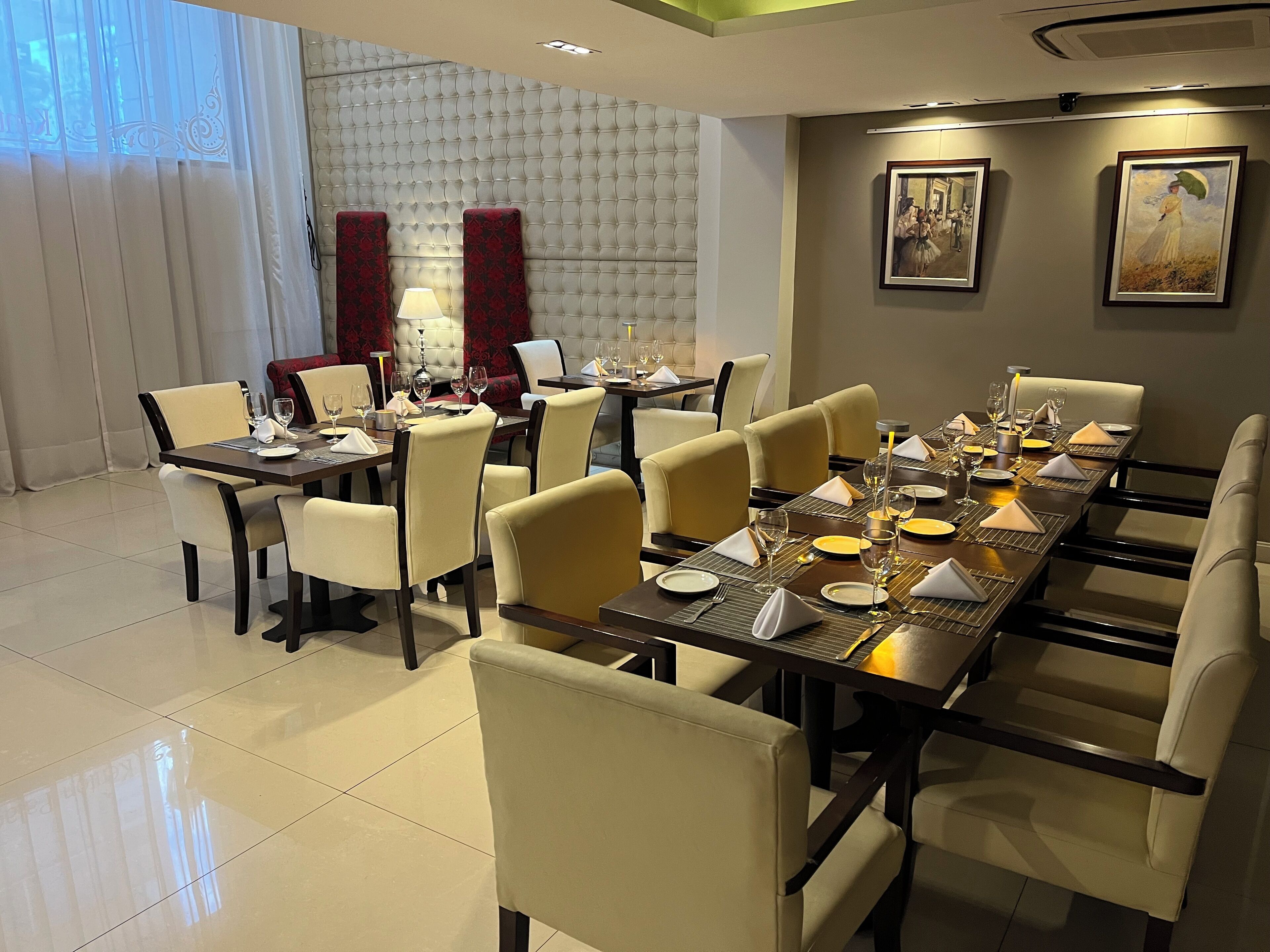 A dining area with a long table set for a meal, surrounded by chairs.