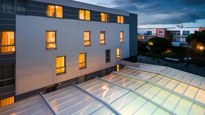 A modern building with multiple windows and a flat roof with skylights. - Lagrange Apart'HOTEL L'Escale Marine (La Rochelle)