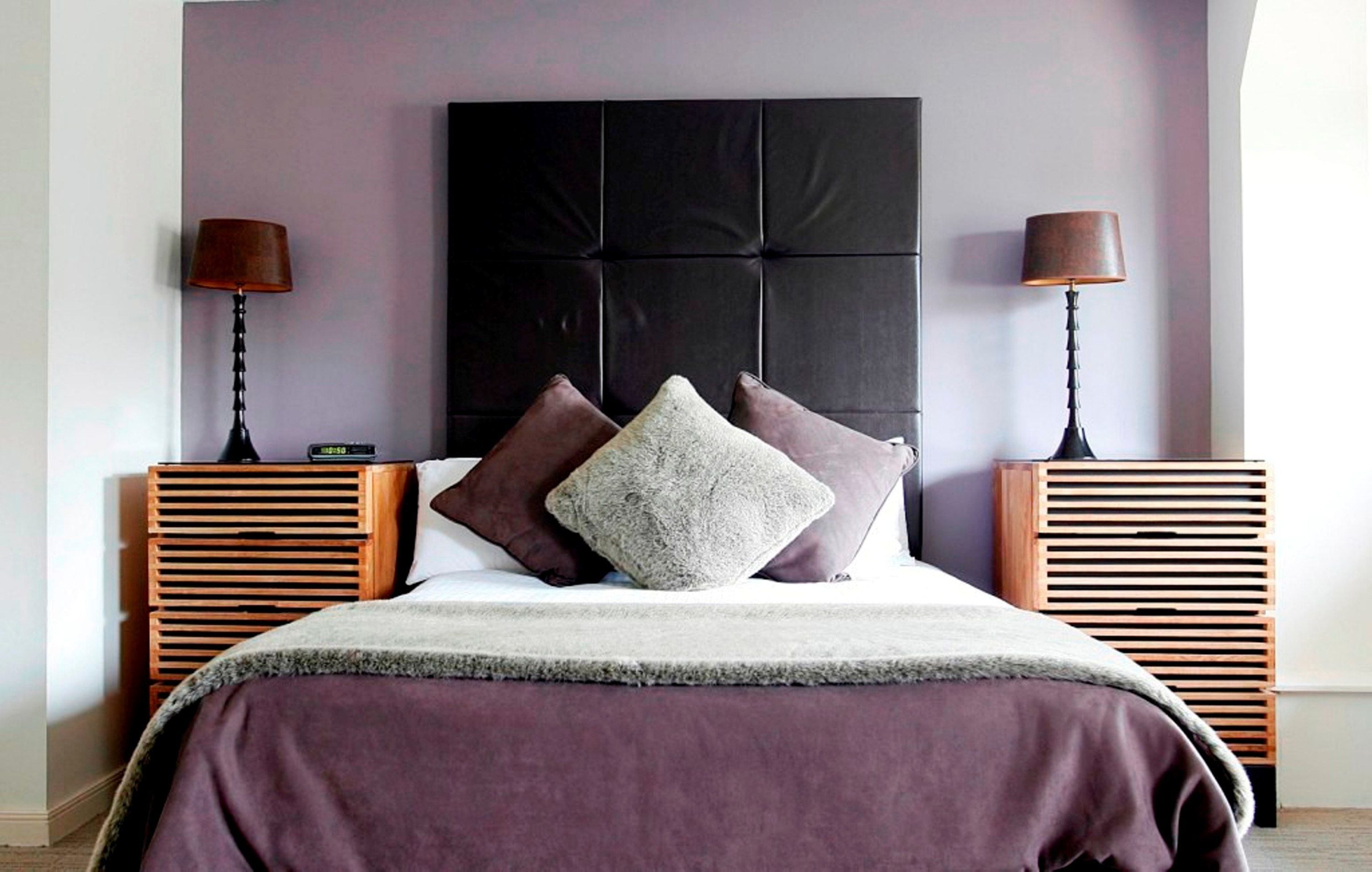 A neatly arranged bedroom with a large bed, two bedside tables, and a headboard.