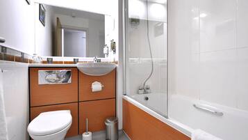 Un baño moderno con inodoro, lavamanos y ducha.