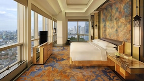 Una camera d'hotel moderna con un letto grande, una televisione e vista sulla città.