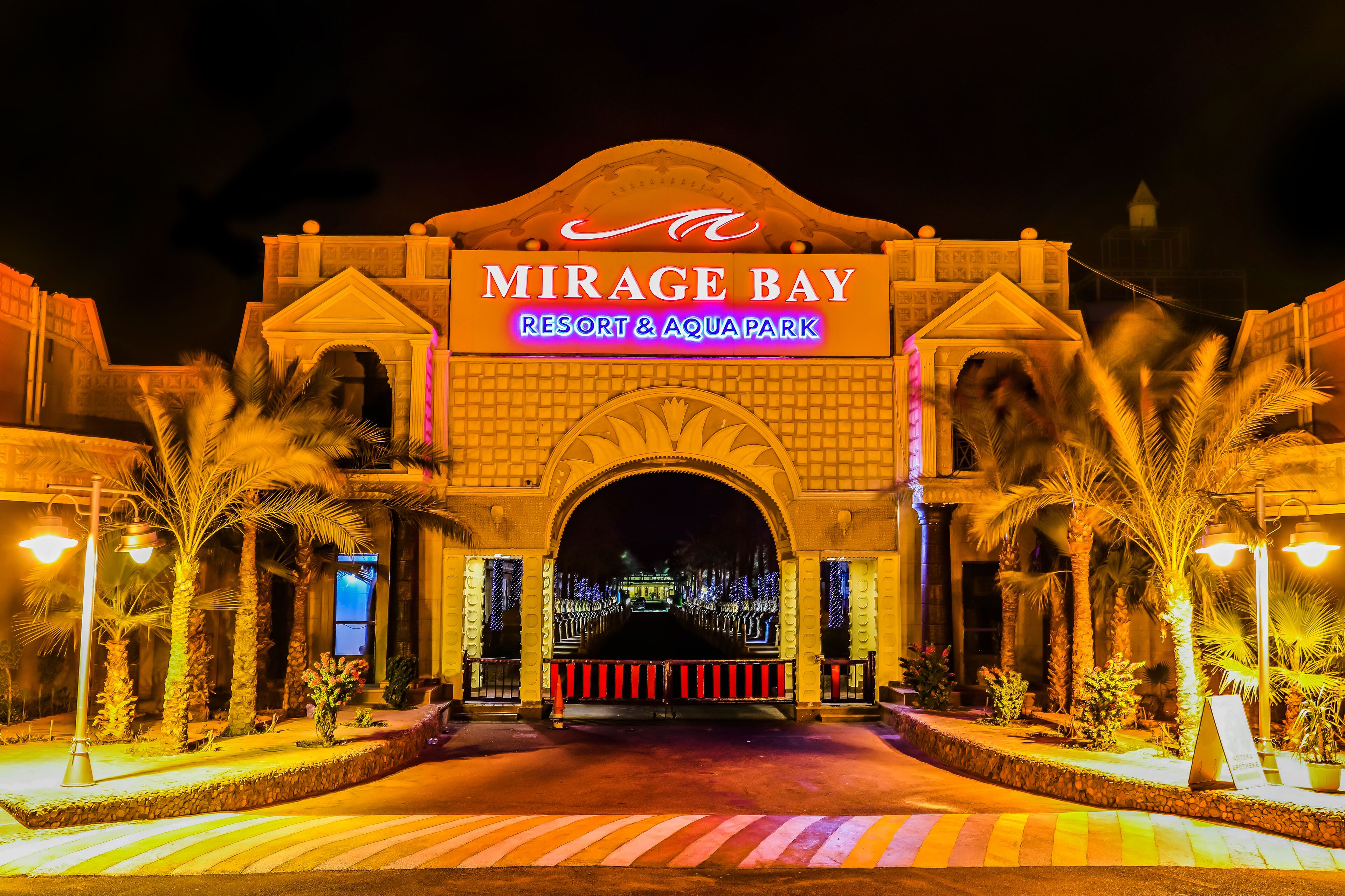 The entrance to Mirage Bay Resort & Aquapark with a prominent archway and illuminated signage.