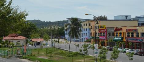 A street view with a row of commercial buildings, including a pizza restaurant and a Canon store.
