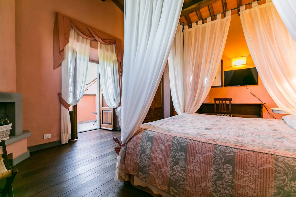 Een slaapkamer met een bed, een televisie, een bureau en een stoel.
