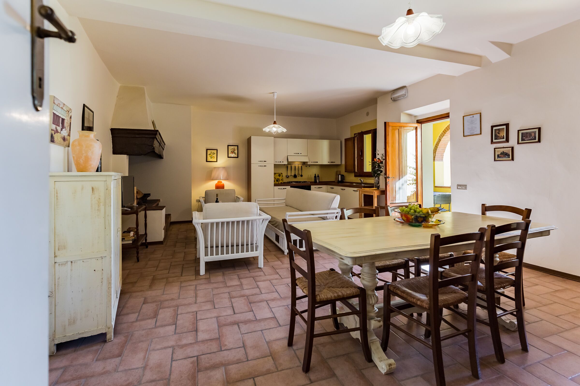 A cozy kitchen with a dining area, featuring a white cabinet, a baby crib, and a table with chairs.
