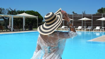 Una piscina al aire libre de temporada, sillones reclinables de piscina