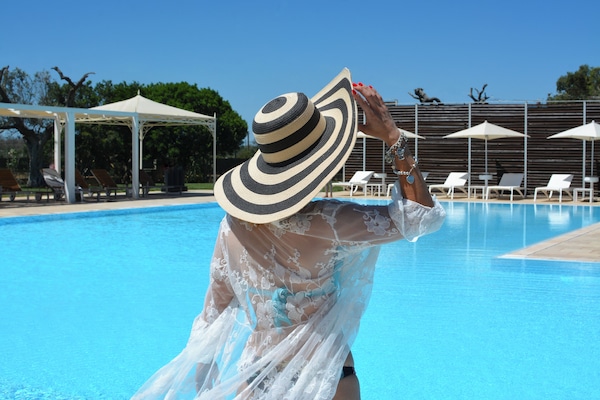 Una piscina al aire libre de temporada, sillones reclinables de piscina